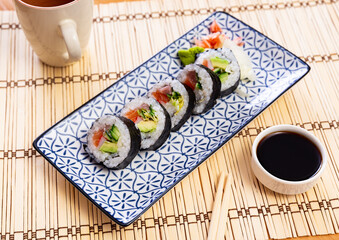 Set of japanese rolls futomaki with soy and chili sauces close-up