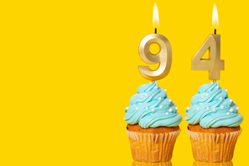 Birthday Cupcakes With Candles Lit Forming The Number 94