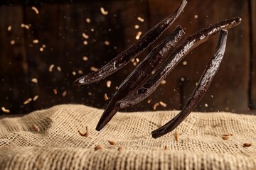 Vanilla beans falling on burlap texture in slow motion. Shot on Phantom Flex 4K camera.