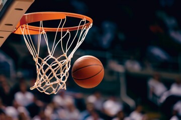 Naklejka premium Basketball ball falling through the hoop in a lit gym
