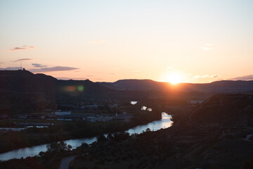 River Valley Sunset: Golden Light over Serene Landscape