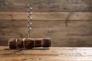 One corkscrew on wooden table, closeup. Space for text