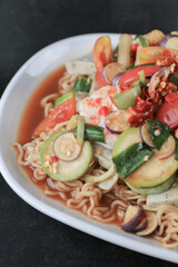 Instant noodles spicy salad with shrimp and vegetable on black table. Yum Mama Thai cuisine Yum traditional spicy hot