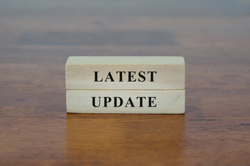 Latest Update message sign on a wooden desk.