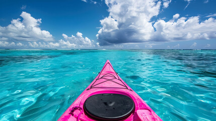 pink kayak navigating clear turquoise waters under a cloudy sky