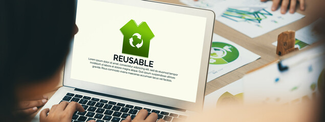 Reusable sign displayed on green business laptop while business team presenting green design to...