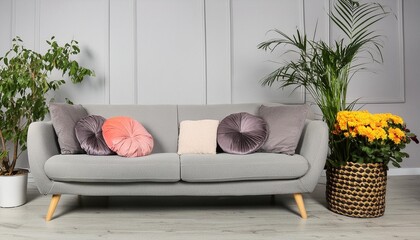 soft gray fabric sofa with cushions and floral decor
