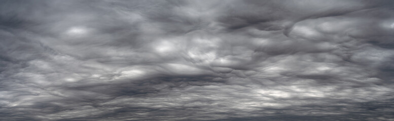 Panorama of spectacular gray storm clouds. The dramatic shapes and tones create interesting...