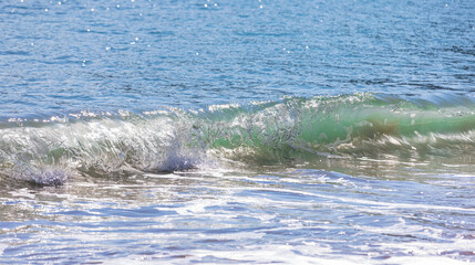 Rough waves of the emerald sea seen from the beach. front view