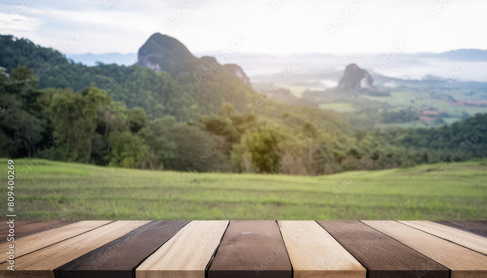 Poster wooden table top on blur mountain and grass field. fresh and relax concept. for montage product disp