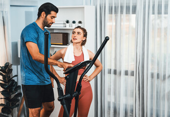 Athletic and sporty young couple or fitness buddy running on running machine together, home body...