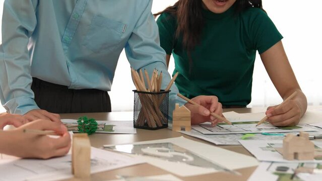 A video of architect use measurement tools and pencil to measure blueprint. Architect design house construction on a table at studio, with architectural plan scattered around. Focus hand. Delineation.
