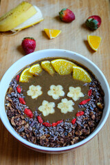 Healthy Raw Cacao chocolate smoothie bowl topping with cacao nibs and cacao granola goji berry banana and orange 