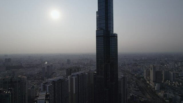 Landmark 81 tower in Ho Chi Minh City, Saigon, the highest building in Vietnam viewed during sunset, aerial ascending drone video