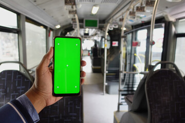 passenger sitting in a bus using his phone with green screen 