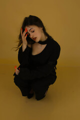 Portrait of a fashion model in the studio dressed in an elegant black jacket and trousers