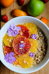 Oatmeal or oat porridge with banana citrus fruits fresh orange and blood oranges and almond 