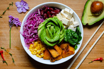 Salad bowl with avocado, baked sweet potatoes, spinach, red cabbage with honey ginger soy sauce dressing 