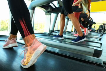 Sportswoman in comfortable sneakers training on treadmill in gym