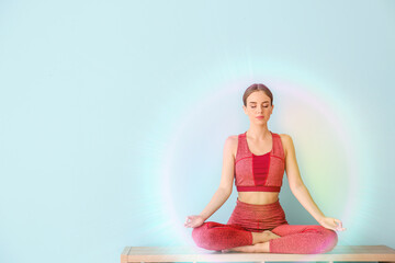 Young woman practicing yoga on color background