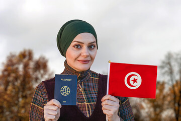 Muslim Woman Holding Passport and Flag of Tunisia
