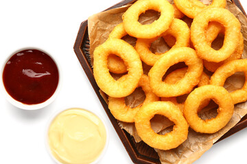Tray with fried breaded onion rings and different sauces on white background