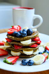 Green tea matcha latte and pancakes made with roll oats, soy milk, banana topping with fresh fruit 