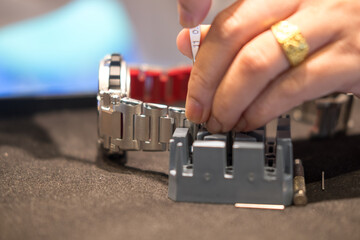 Watchmaker using spring bar tool. Spring bar tool used to remove spring bars to change watch strap.