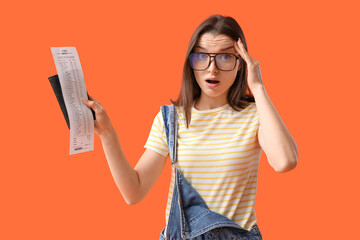 Shocked young woman with store receipt and wallet on orange background. Price rise concept