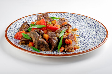 Fragrant roast of offal, lamb or beef meat with tomatoes and onions in a plate, isolated on white. A Central Asian dish made from the heart or lung of mutton.