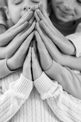 Family praying together at home, closeup