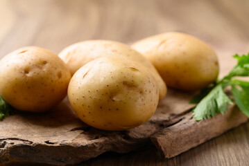 Raw potatoes on wooden background, Food ingredient