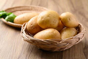 Raw potatoes in basket on wooden background, Food ingredient