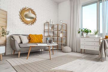 Interior of living room with golden mirror, sofa and shelf unit