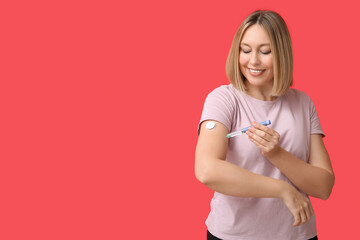 Woman with lancet pen and glucose sensor on red background. Diabetes concept