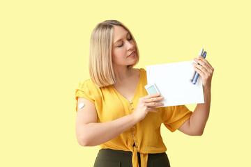 Naklejka premium Woman with glucometer, sensor for measuring blood sugar level, lancet pens and blank paper on yellow background. Diabetes concept
