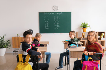 Little pupils having Math lesson at desks in classroom
