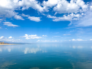 Fototapeta premium Sunny summer day on the lake. Mountains and sea. Kyrgyzstan, Lake Issyk-Kul