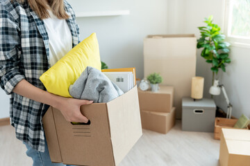 Moving house, relocation. Woman hold carton box contain equipment for new condominium, inside the...