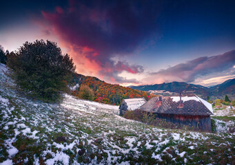 First snow in abandoned mountain farmland. Majestic sunset in Carpathian mountains, Kvasy village...