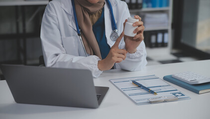 Cropped view of doctor in white coat holding bottle medication, prescribing pills to sick patient via online consultation. Family therapist recommend quality medicines. Healthcare, treatment concept