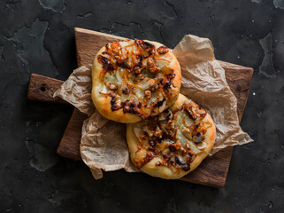 Vegetarian mini pizza with caramelized pear, blue cheese, honey and walnuts on a wooden chopping...