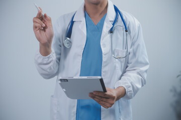 Mature male doctor with tablet pc is giving presentation. Blurred background indoors.
