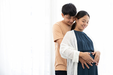 happy couple hands touching and hugging pregnant belly and making their hands in heart shape