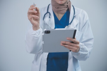 Doctor wearing white coat and watching patient data in Tablet .