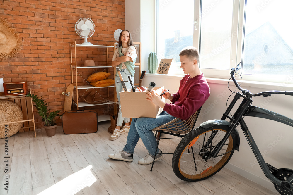 Wall mural Young couple with unwanted stuff in room