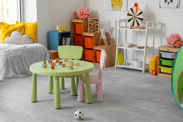 Interior of modern children's room with table and toys