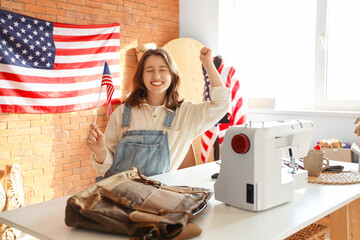 Young tailor with USA flag at table in atelier - Powered by Adobe