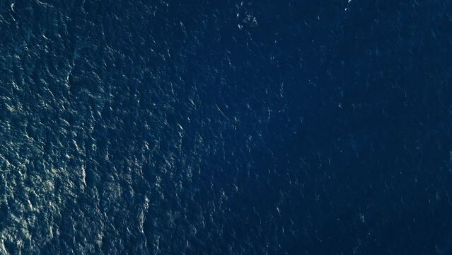Bird's eye view static shot of ocean water current ripples textured across sea surface