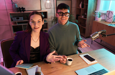 Young couple recording podcast in studio